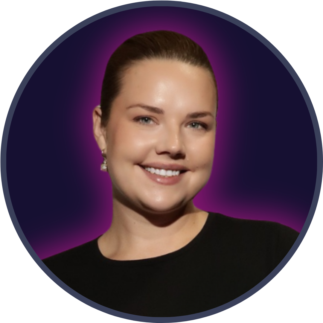 Headshot of a white woman with brown hair in a ponytail smiling at the camera in front of a purple background
