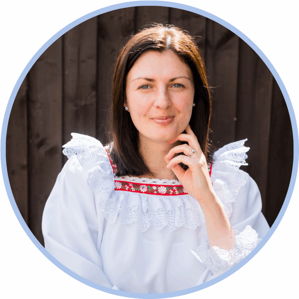 White woman with dark brown hair smiling and holding her hand to her face