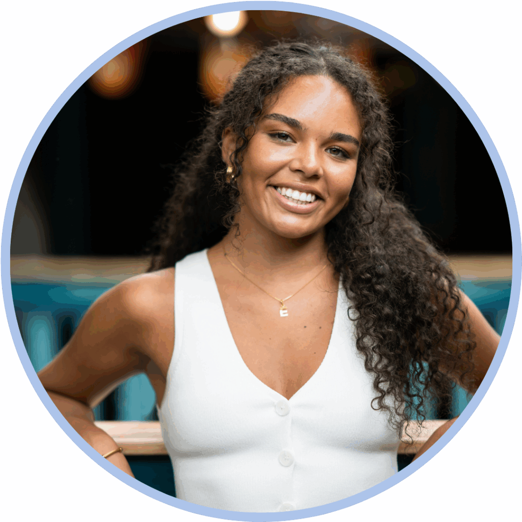 Headshot of a black woman with dark hair wearing a white tip and smiling