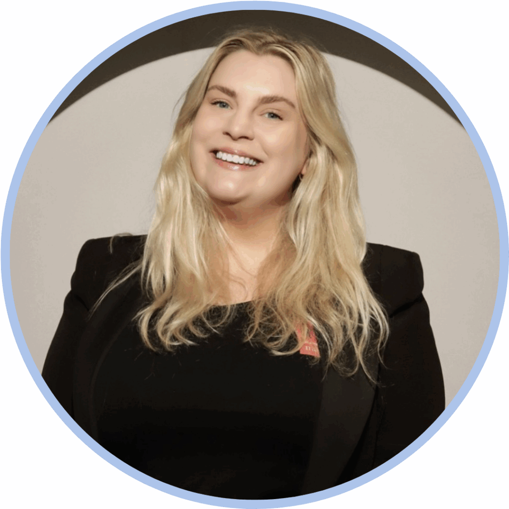 Headshot of a white woman with blonde hair smiling to the camera