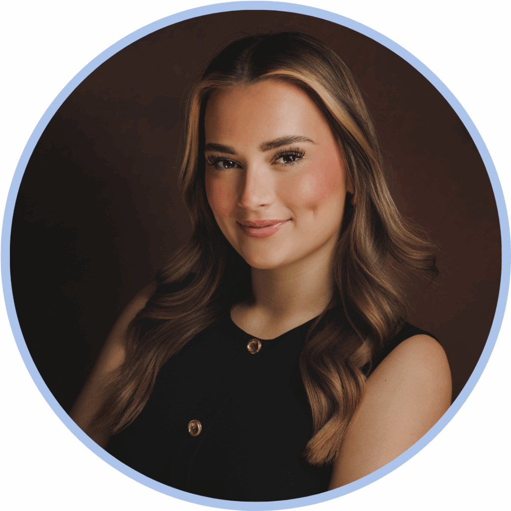 Headshot of a white woman with light brown hair smiling to camera