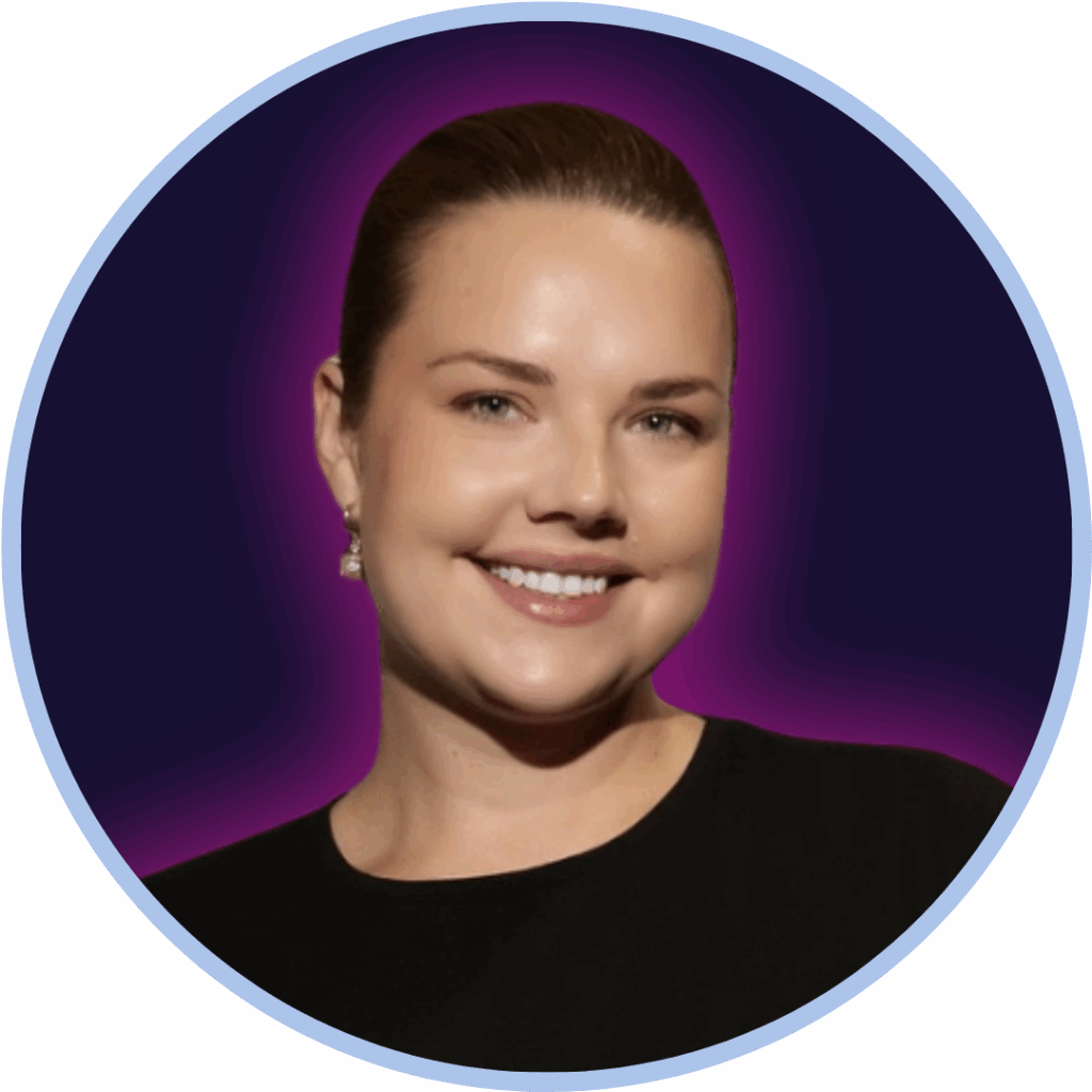 Headshot of a white woman in front of a purple background smiling to camera